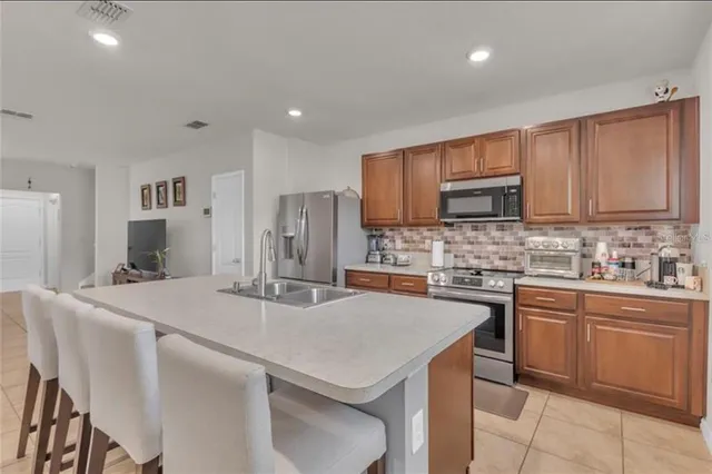 a kitchen with kitchen island granite countertop a sink stove and refrigerator