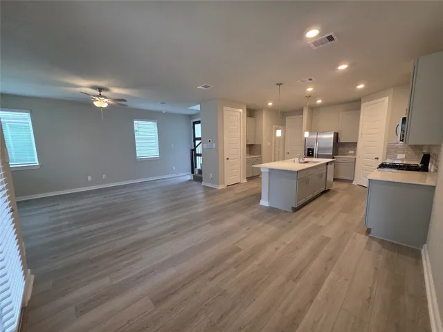 a view of kitchen with kitchen island wooden floor and center island