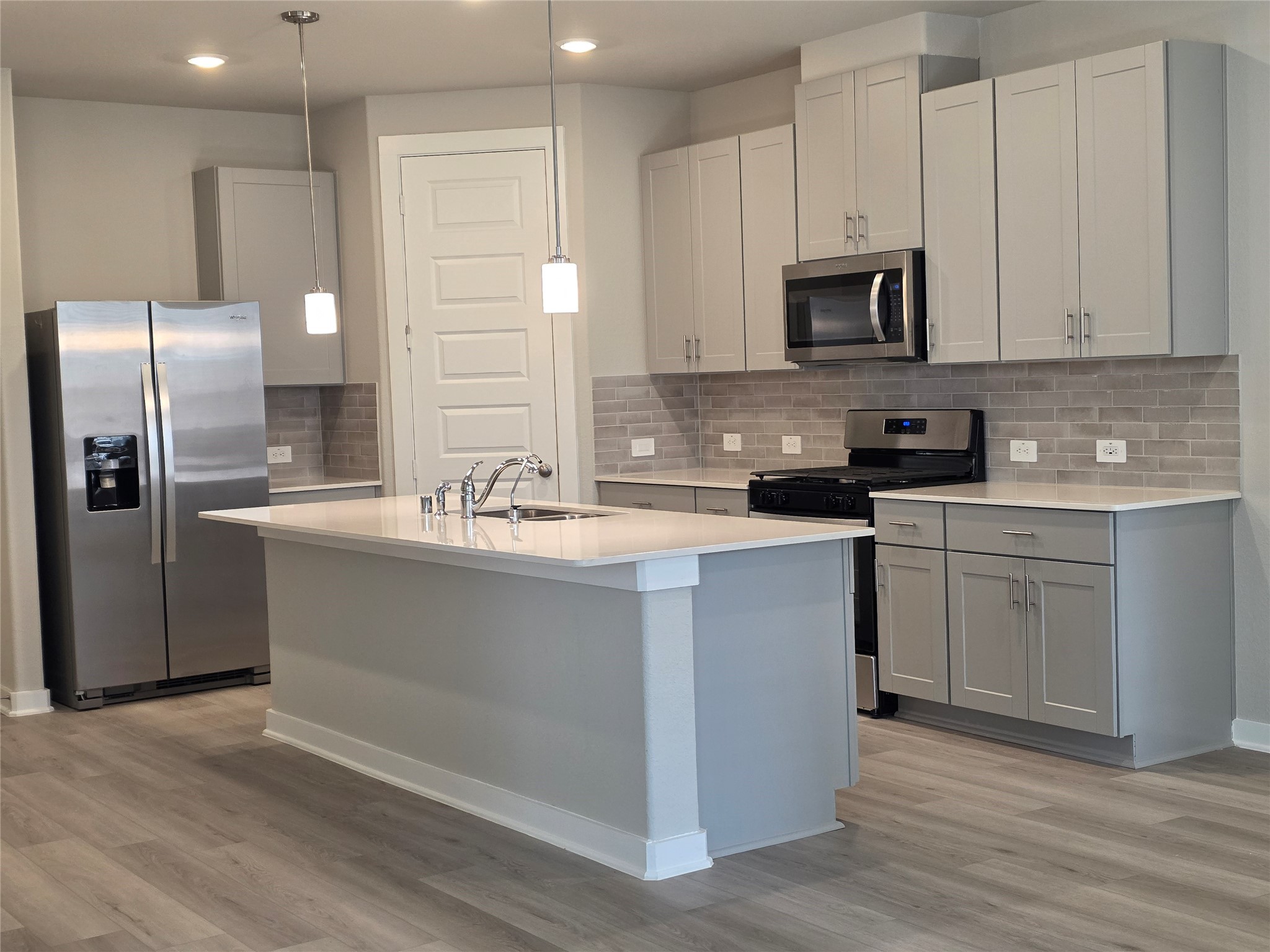 4114 Glowing Hearth Drive Houston, TX 77080 - Photo 5 of 14 a kitchen with stainless steel appliances a sink a stove a microwave a sink a refrigerator and cabinets