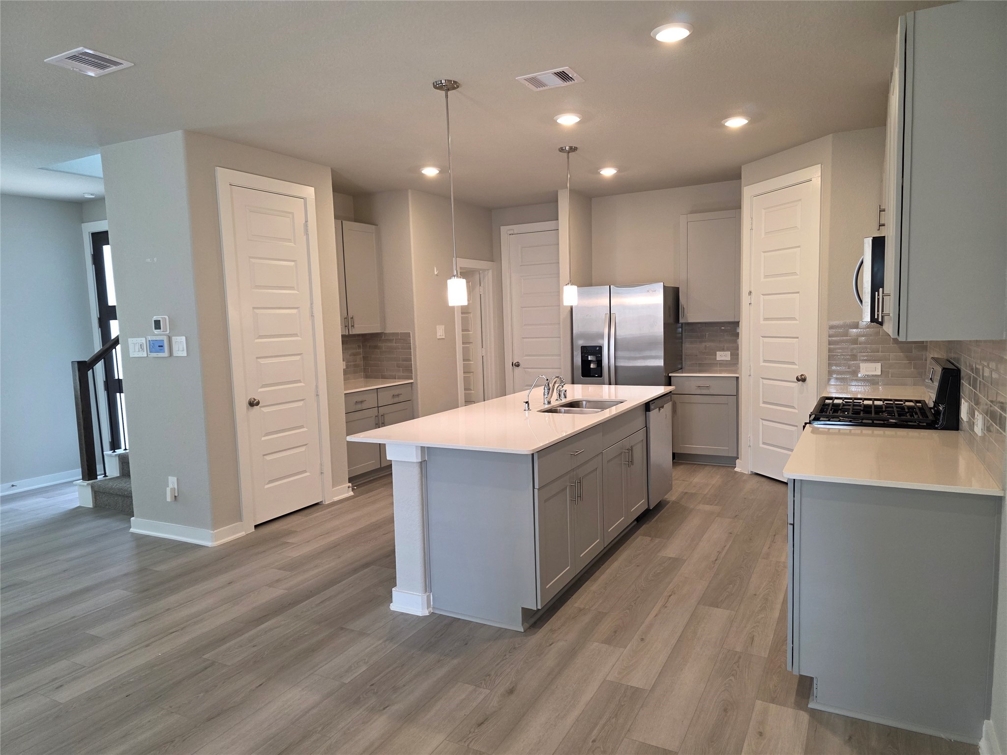 4114 Glowing Hearth Drive Houston, TX 77080 - Photo 6 of 14 a large kitchen with stainless steel appliances a sink and wooden floor