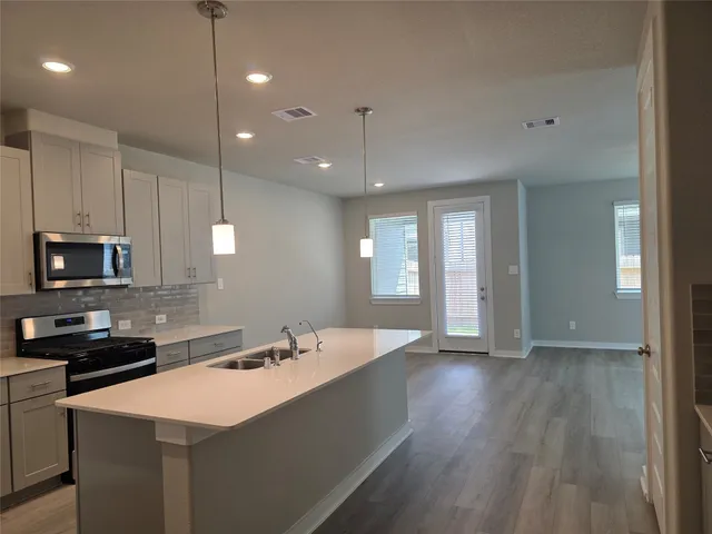 a kitchen with a sink a microwave and cabinets