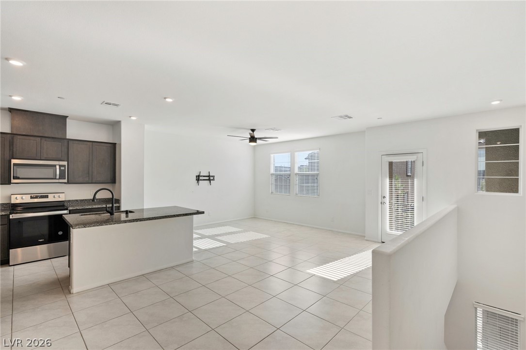 6227 Runestone Street Las Vegas, NV 89113 - Photo 17 of 33 Bright and open-concept living space with a functional kitchen island and tile flooring.