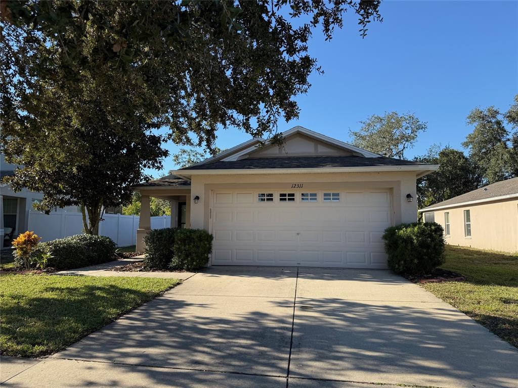 12311 Boot Spur Way Spring Hill, FL 34610 - Photo 1 of 25 a front view of a house with a yard and garage