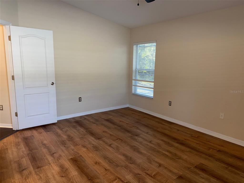 12311 Boot Spur Way Spring Hill, FL 34610 - Photo 12 of 25 a view of empty room with wooden floor and fan