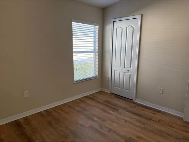 a view of an empty room with wooden floor