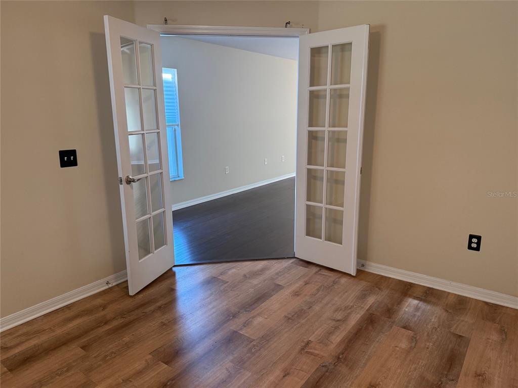 12311 Boot Spur Way Spring Hill, FL 34610 - Photo 4 of 25 an empty room with wooden floor and windows