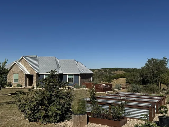 a front view of a house with a garden