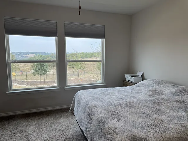 a bedroom with a large window and a bed
