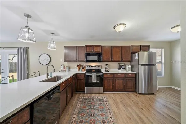 a large kitchen with stainless steel appliances granite countertop a sink stove and refrigerator