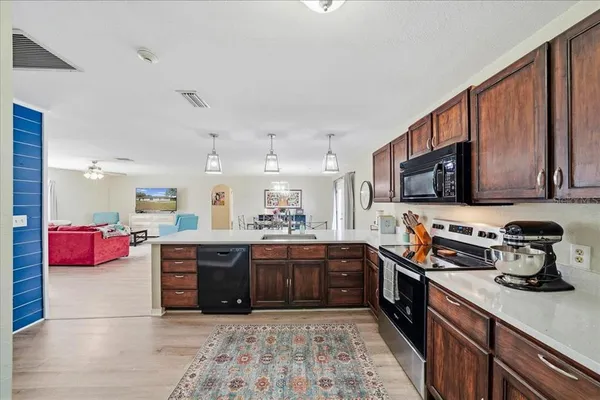 a large kitchen with stainless steel appliances granite countertop a stove and cabinets