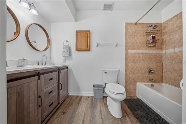 a spacious bathroom with a granite countertop sink a toilet and a bathtub