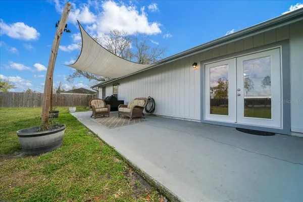a view of a patio with a table chairs and a small yard