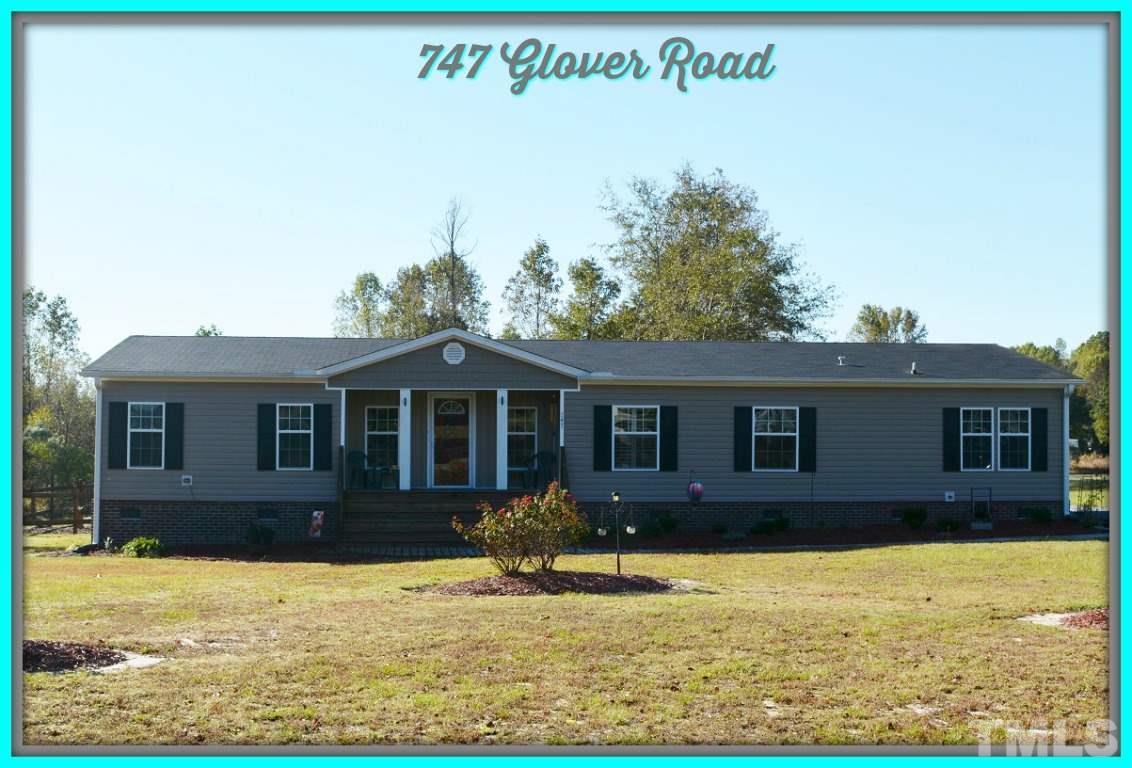 747 Glover Road Dunn, NC 28334 - Photo 1 of 25 a view of a house with yard and trees in front of it