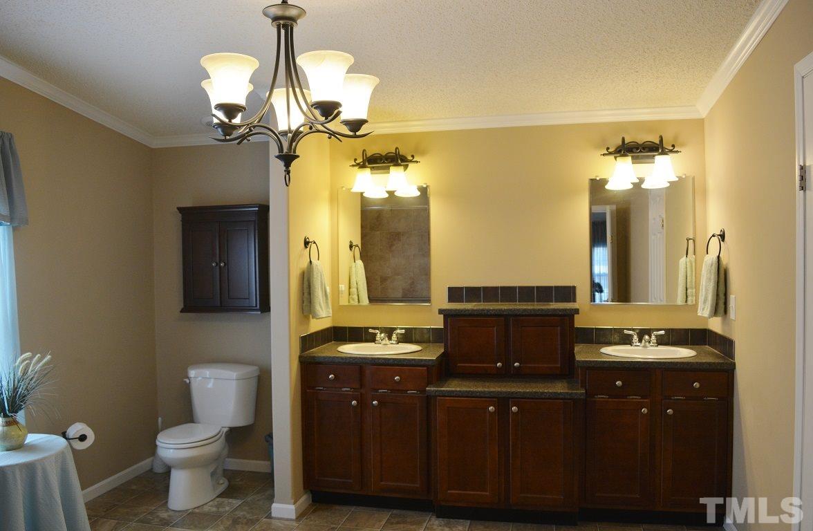 747 Glover Road Dunn, NC 28334 - Photo 11 of 25 a bathroom with a double vanity sink and a toilet