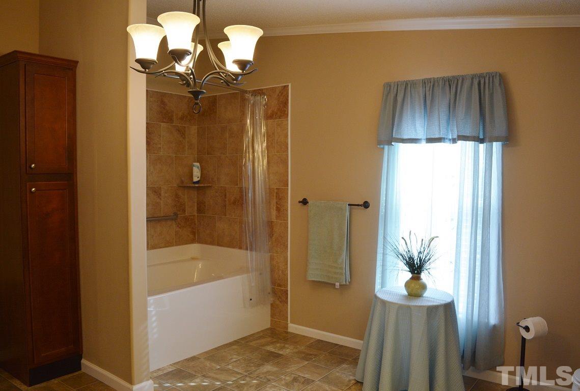 747 Glover Road Dunn, NC 28334 - Photo 12 of 25 a bathroom with a tub shower and sink