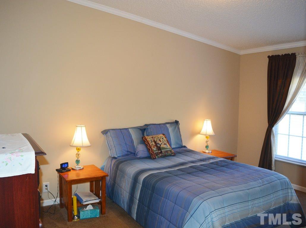 747 Glover Road Dunn, NC 28334 - Photo 13 of 25 a bedroom with a bed and a lamp on table