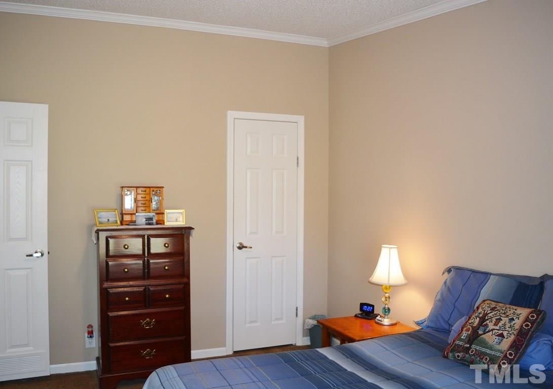 747 Glover Road Dunn, NC 28334 - Photo 14 of 25 a bedroom with a bed and wooden floor