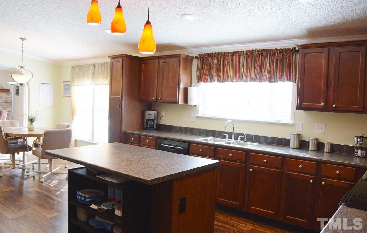 747 Glover Road Dunn, NC 28334 - Photo 8 of 25 a kitchen with a sink a stove a kitchen island and chairs