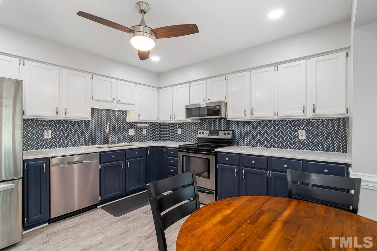 1426 Mapleside Court Raleigh, NC 27609 - Photo 11 of 38 a kitchen with stainless steel appliances granite countertop a sink a stove and cabinets