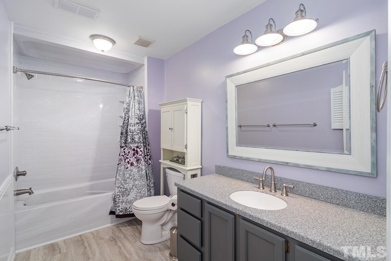 1426 Mapleside Court Raleigh, NC 27609 - Photo 25 of 38 a bathroom with a granite countertop sink toilet a mirror and shower