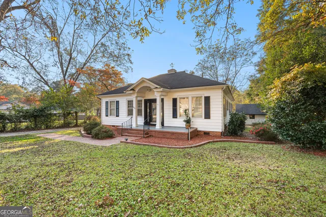 a front view of a house with a yard and trees