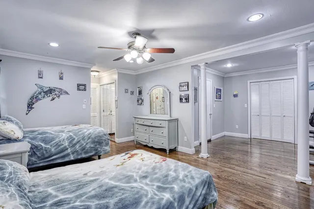 a spacious bedroom with a large bed a chandelier and closet