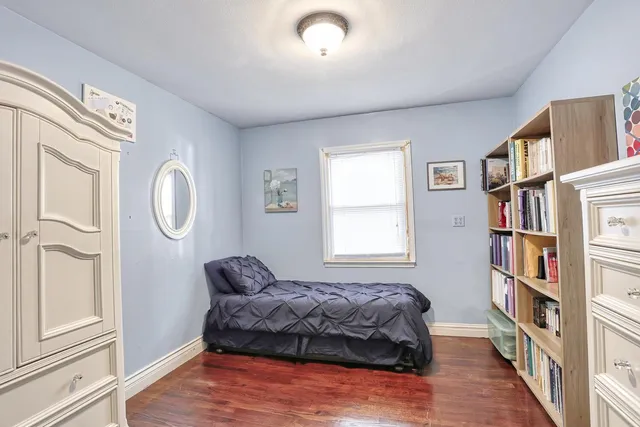 a spacious bedroom with a bed a dresser and a book shelf