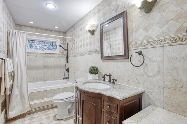 a bathroom with a granite countertop sink toilet and shower