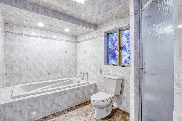 a bathroom with a granite countertop shower sink vanity and mirror