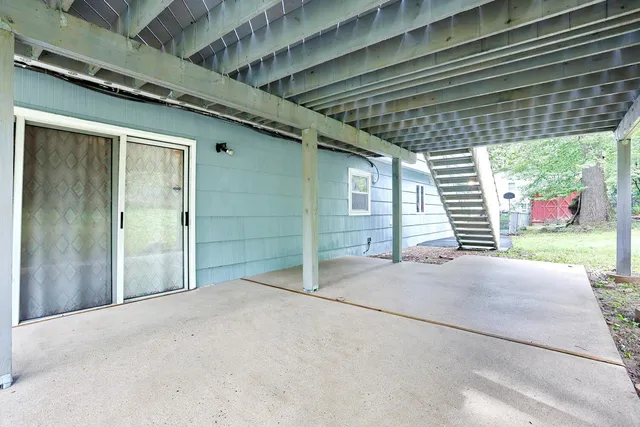 a view of a backyard with a small deck and a garden