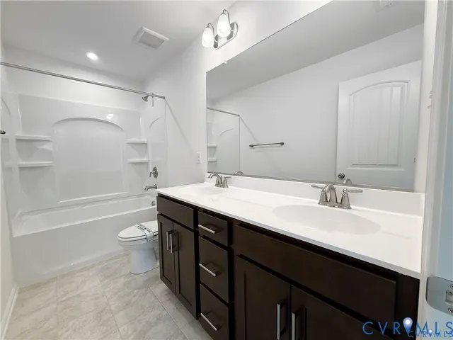 a bathroom with a sink a toilet a mirror and shower