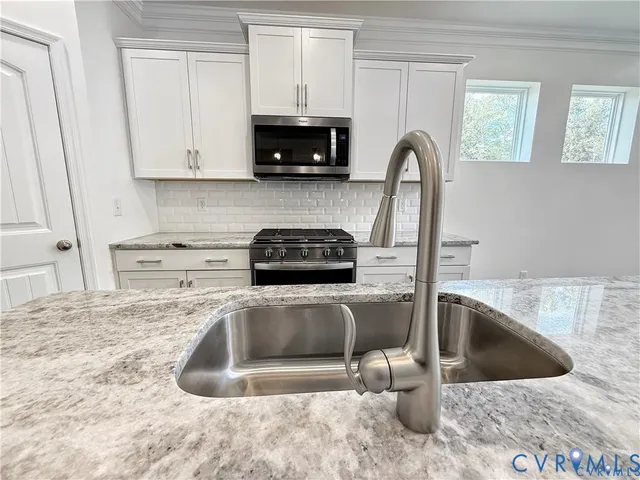 a kitchen with a sink and a stove top oven