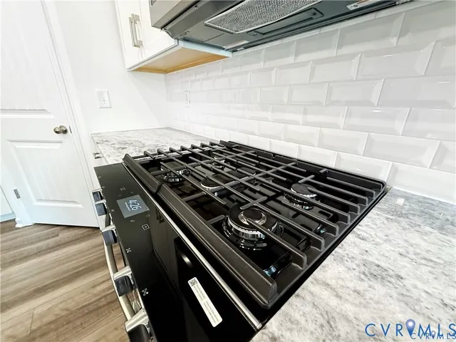 a stove sitting inside of a kitchen with granite countertop