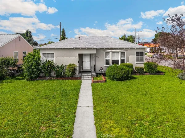 a front view of a house with a yard and potted plants