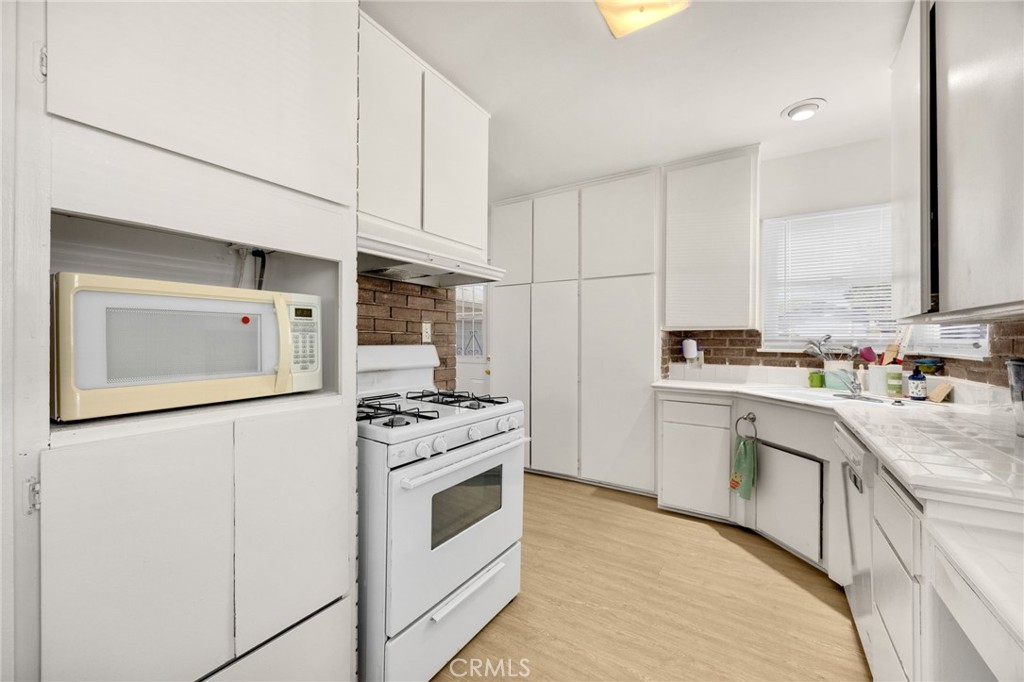 4577 Ranger Avenue El Monte, CA 91731 - Photo 16 of 25 a kitchen with stainless steel appliances granite countertop white cabinets a sink a stove a refrigerator and white cabinets