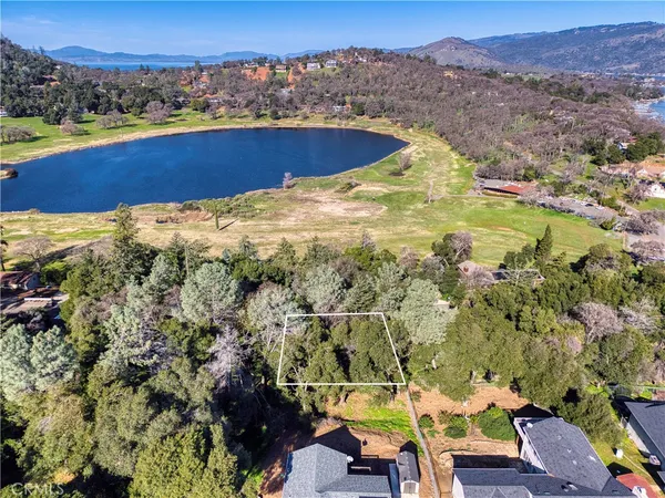 an aerial view of residential houses with outdoor space and lake view