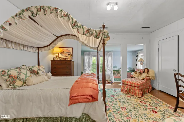 a bedroom with bed and a large windows