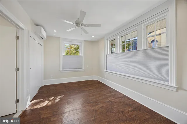 a view of empty room with window and ceiling fan