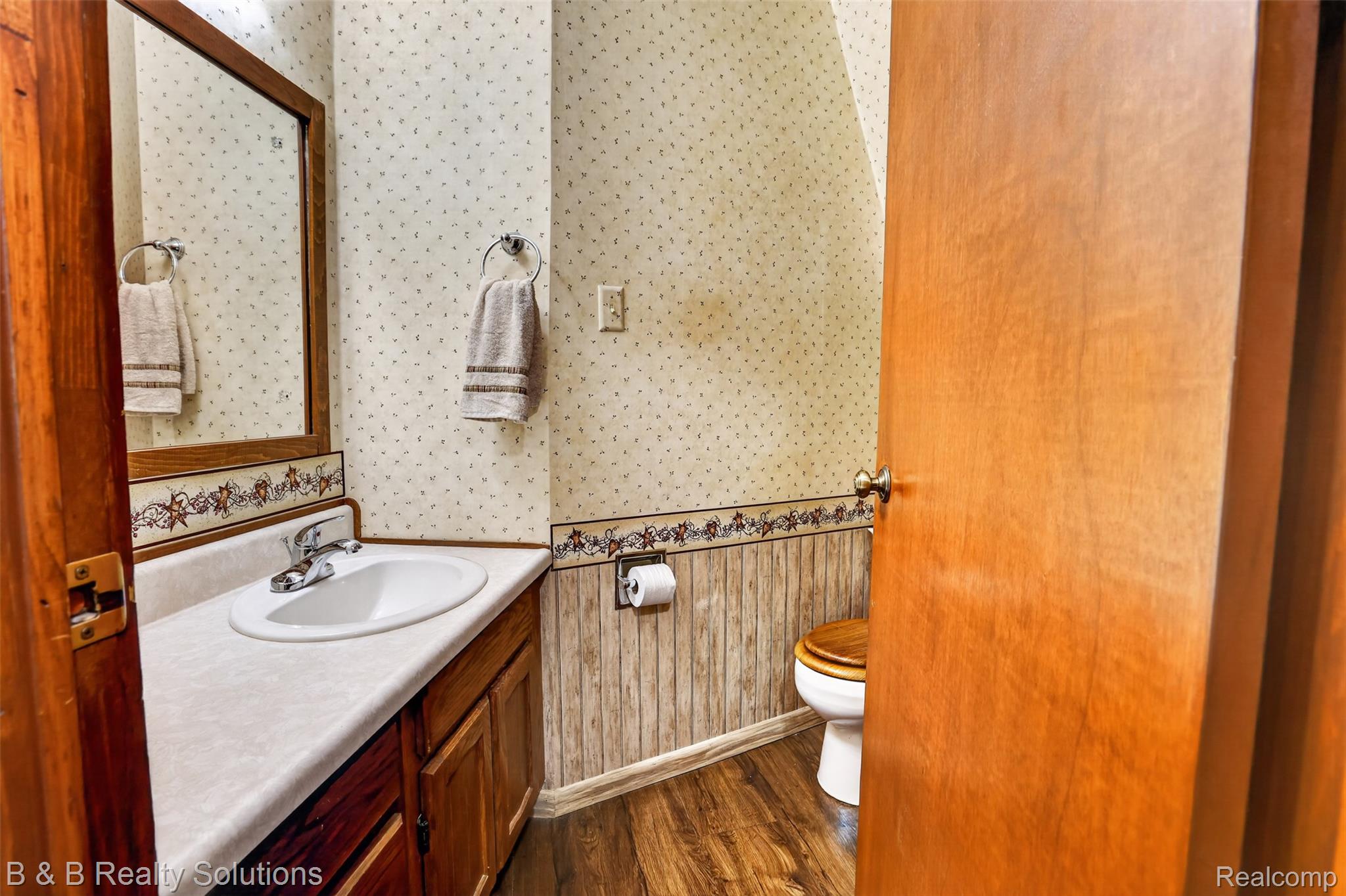 5544 Piersonville Road Columbiaville, MI 48421 - Photo 23 of 49 Bathroom vanity featuring a white oval sink with chrome faucet, light countertop, and wood-finish cabinetry
