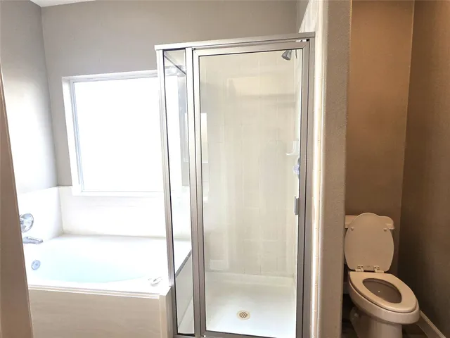a bathroom with a toilet and a shower