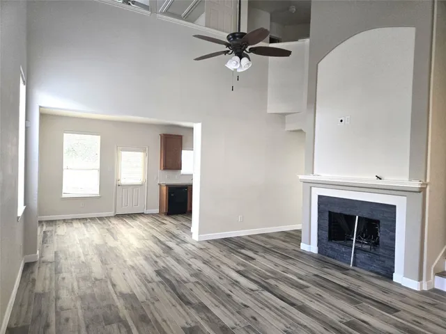wooden floor fireplace and windows in an empty room