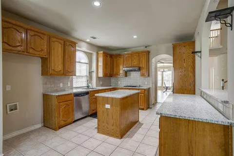 a kitchen with stainless steel appliances granite countertop a stove a sink and a refrigerator