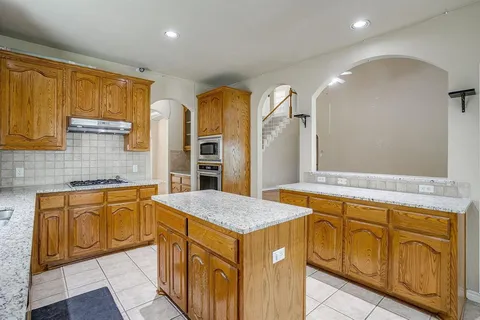 a kitchen with granite countertop a sink stove and cabinets