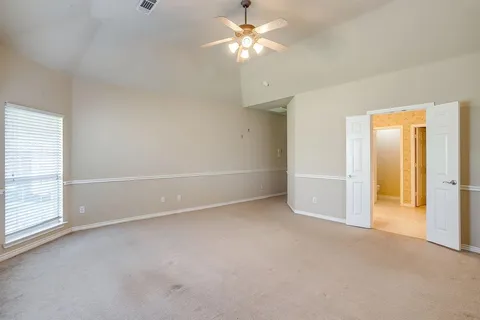 an empty room with closet and a ceiling fan
