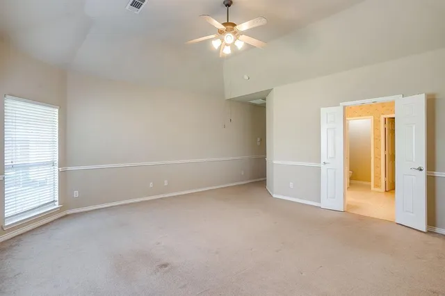 an empty room with closet and a ceiling fan