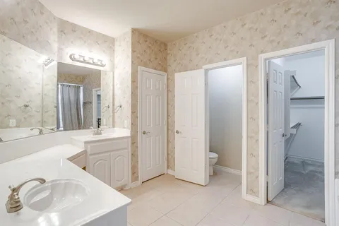 a spacious bathroom with a bathtub sink and mirror