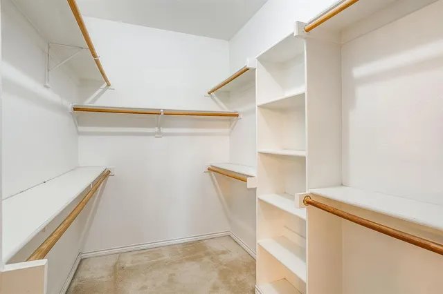 a view of walk in closet with empty racks