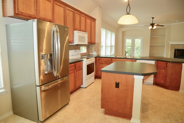 138 Chestnut Court Georgetown, TX 78633 - Photo 6 of 25 A warm kitchen features light wood cabinetry, stainless appliances, and a convenient central island, flowing into a naturally illuminated dining area.