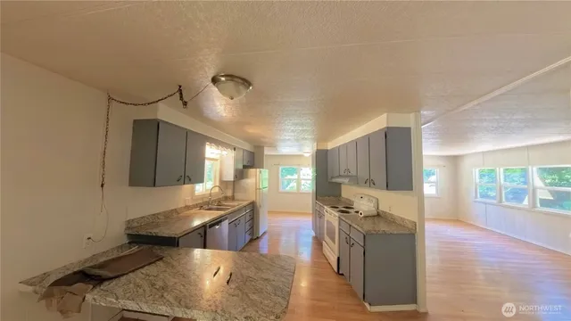a living room with stainless steel appliances kitchen island granite countertop furniture and a kitchen view