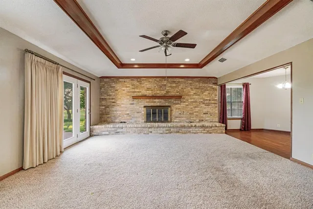 a view of an empty room with a fireplace and a window